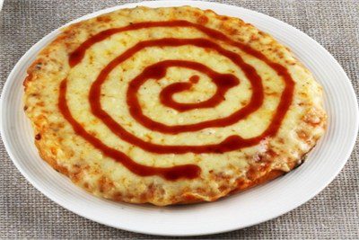 Image of an extra cheese pizza served in a white colour plate kept on a table covered with a cloth