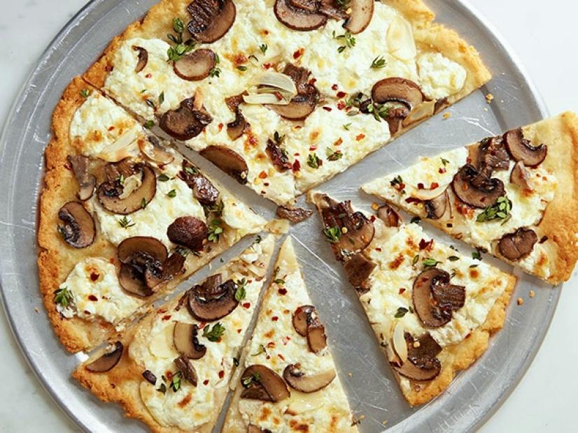 Image of a sliced mushroom pizza served in a steel plate