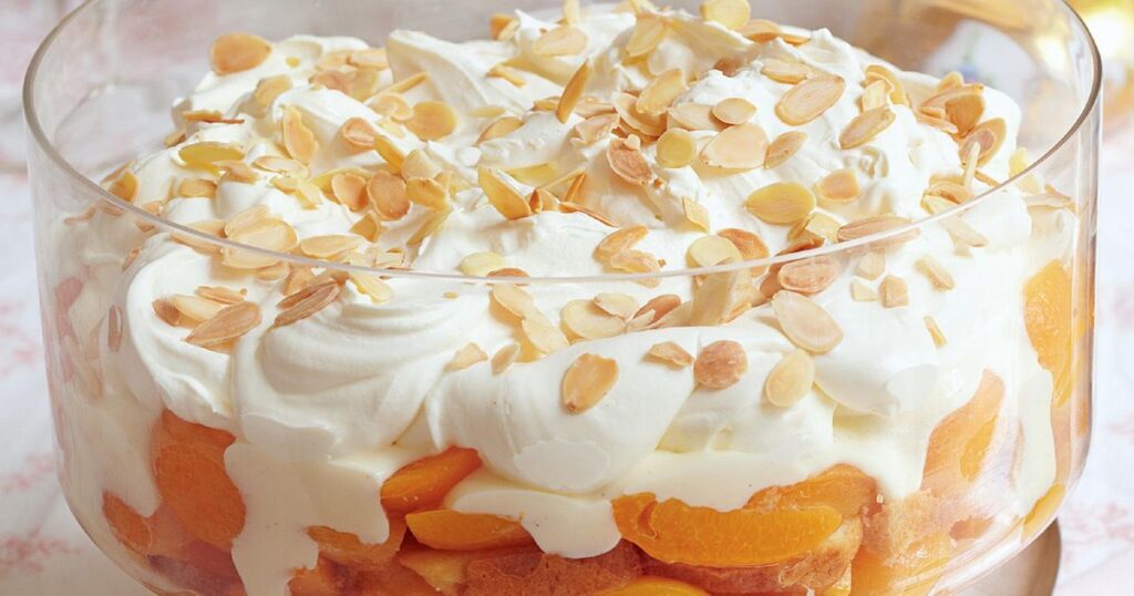 Image of creamy and delicious apricot sponge cake trifle in a transparent bowl